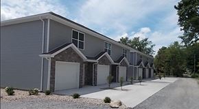 Lima apartment for rent - a row of gray houses with white doors and a sidewalk