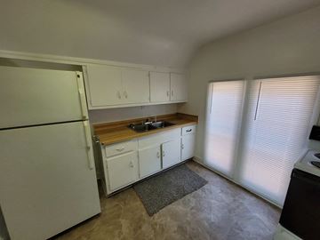 Lima apartment for rent - A kitchen with white cabinets and a refrigerator.