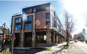 Vancouver apartment for rent - A modern building with a glass facade is situated on a street corner.