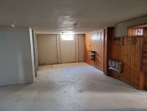 Lima house for rent - a living room with wood paneling on the wall and a concrete floor