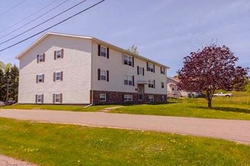 Charlottetown apartment for rent - A two-story building with a red tree in front.