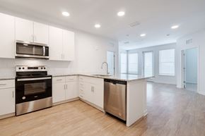 Bradenton apartment for rent - an empty kitchen with white cabinets and stainless steel appliances