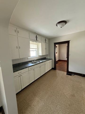 Lima house for rent - A kitchen with white cabinets and a brown floor.