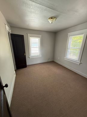 Lima house for rent - A room with a carpeted floor, a door, and a window.