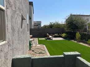 Goodyear house for rent - a backyard with a green lawn and a garden
