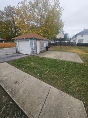Lima house for rent - A basketball hoop stands in a backyard with a shed and a concrete walkway.