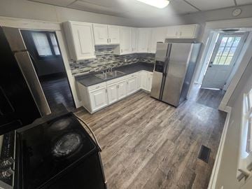 Lima house for rent - A kitchen with a black stove top oven and a black refrigerator.