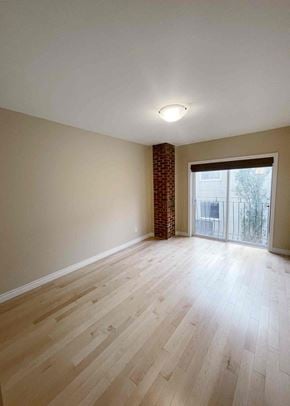 Edmonton apartment for rent - an empty living room with wood floors and a sliding glass door