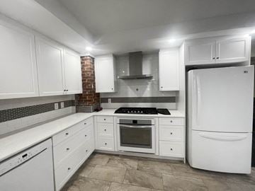 Edmonton apartment for rent - a kitchen with white cabinets and a white refrigerator