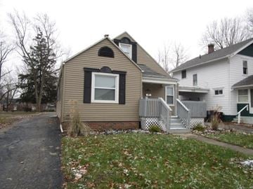 Lima house for rent - a tan house with a black window and a sidewalk