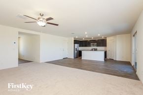 Buckeye house for rent - an empty living room and kitchen with a ceiling fan