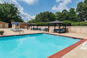 Laurel apartment for rent - a resort style pool with chairs and gazebos on the side