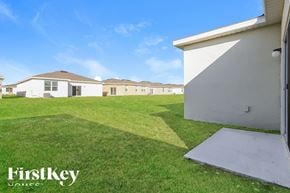 Bartow house for rent - a backyard with grass and houses in the background