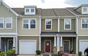 Duncan house for rent - a yellow house with a red door and white garage doors