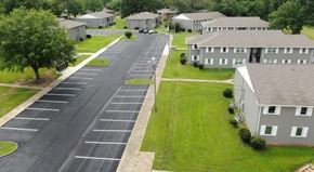 Canton apartment for rent - A parking lot in front of a building with a green lawn.