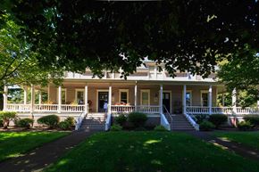 Vancouver apartment for rent - A white house with a porch and a tree in front.
