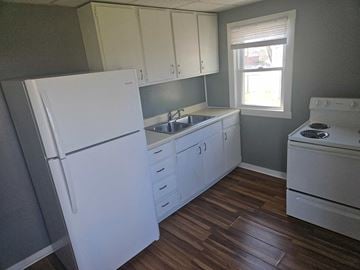 Lima apartment for rent - a kitchen with white cabinets and a sink and refrigerator