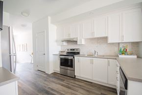 Arnprior house for rent - a renovated kitchen with white cabinets and stainless steel appliances