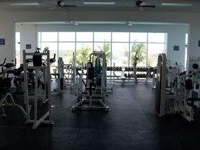 Tamuning apartment for rent - a gym with a view of the beach and palm trees