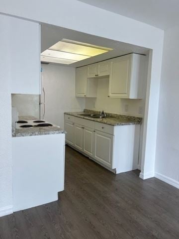 Fort Myers apartment for rent - A kitchen with white cabinets and a marble countertop.