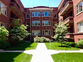 Chicago apartment for rent - A red brick building with a white pathway in front.