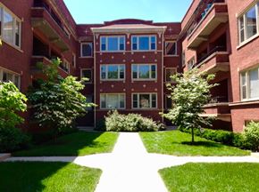 Chicago apartment for rent - A red brick building with a white pathway in front.
