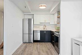 Sacramento apartment for rent - a kitchen with black and white cabinets and a refrigerator