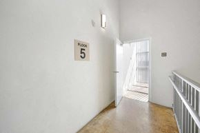 Miami apartment for rent - a hallway with a door to a room 5 and a sign on the wall
