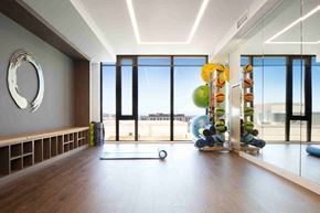 Seattle apartment for rent - a workout room with weights and other exercise equipment in a building with large windows