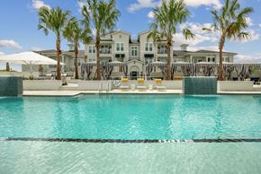 Daytona Beach apartment for rent - A swimming pool in front of a large house with a white umbrella.