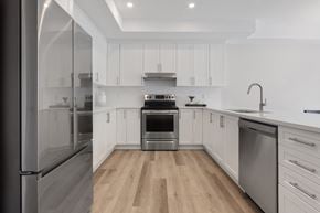 Arnprior apartment for rent - a renovated kitchen with white cabinets and stainless steel appliances