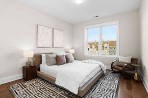 Greenwich apartment for rent - A bedroom with a large bed and a window overlooking a cityscape.