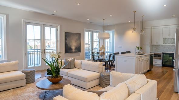 Greenwich apartment for rent - A modern living room with white furniture and a large window.