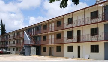 Tamuning apartment for rent - the outside of a building with balconies and a car parked in front