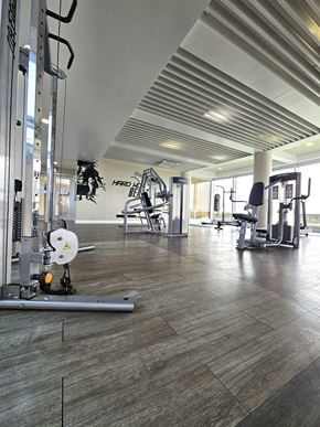 Tamuning apartment for rent - A gym with a variety of equipment including a weight bench and a squat rack.
