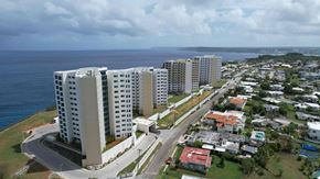 Tamuning apartment for rent - A coastal city with apartment buildings and a road.