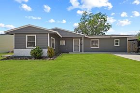 Houston house for rent - a gray house with a lawn and a driveway