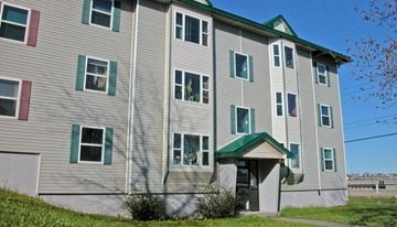 Saint John apartment for rent - A grey building with green trim and a green roof.