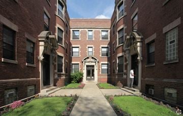 Chicago apartment for rent - a walkway between two brick buildings with grass and flowers