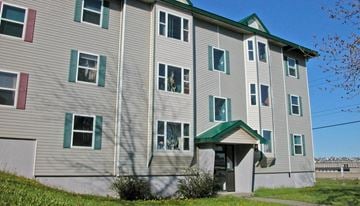 Saint John apartment for rent - A grey building with green trim and a green roof.