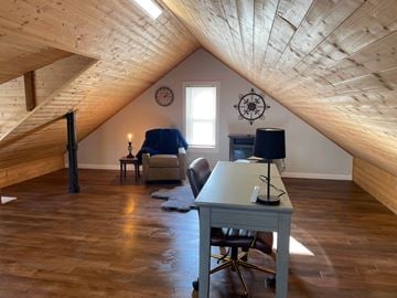 Rochester apartment for rent - an attic office with a desk and chair and a window