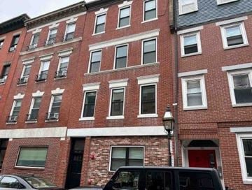 Boston apartment for rent - a red brick building with cars parked in front of it