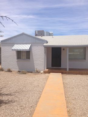 Tucson apartment for rent - a small white house with a sidewalk in front of it