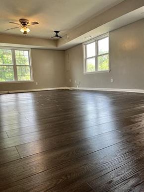 Washington apartment for rent - an empty living room with wood floors and a ceiling fan