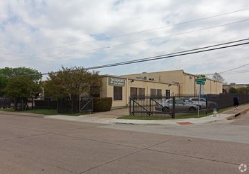 Dallas apartment for rent - a building on the corner of a street with a fence
