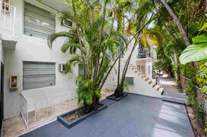 Miami apartment for rent - A white building with a blue pool in front.