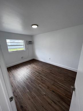 Miami apartment for rent - A room with wooden flooring and a window.