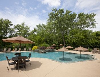 A pool with a table and chairs around it.