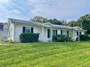 New Albany apartment for rent - A white house with a grey roof and a green lawn in front.