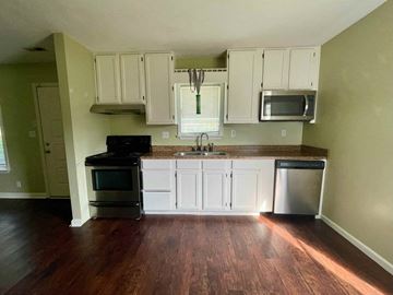 New Albany apartment for rent - A kitchen with white cabinets and a wooden floor.